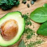 Kuvassa on halkaistu avocado puu leikkuulaudalla