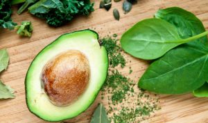 Kuvassa on halkaistu avocado puu leikkuulaudalla