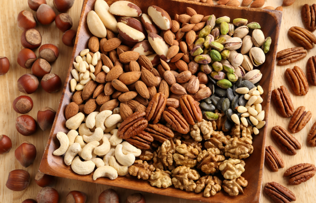 Lautasellinen erilaisia pähkinöitä: saksanpähkinöitä, manteleita, cashew-, pistaasi- ja brasilianpähkinöitä.