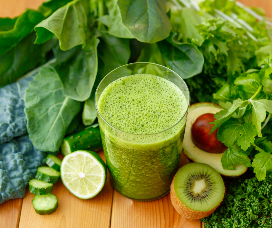 Vihersmoothie, jossa kiibiä, limeä, kurkkua, avokadoa, pinaattia ja lehtikaalia; lisäksi kaikkia näitä kuvassa smoothielasin vieressä.
