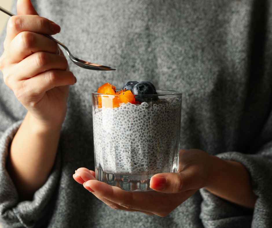 Kuvassa nainen, joka on alkamassa syömään chia vanukasta. Kuva on lähikuva, jossa naista ei näy, mutta paita ja käsi näkyvät. Chian siemenet voivat auttaa painonhallinnassa