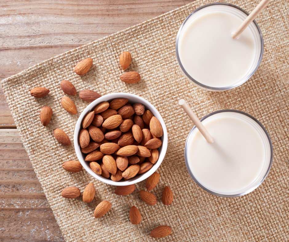 Kuvassa valkoisessa pienessä kulhossa manteleita. Lisäksi kuvassa näkyy kaksi lasia, joissa on mantelimaitoa. Nämä ovat hyviä kalsiumin lähteitä.