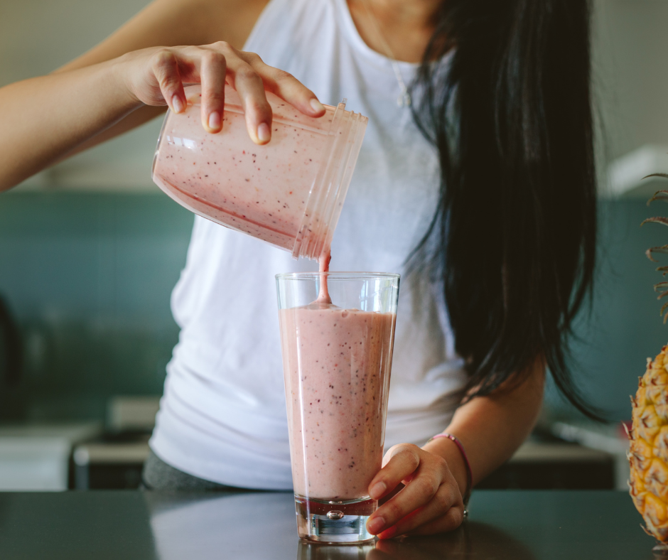 Kuvassa nainen kaataa smoothieta lasiin. Aamiaista ei kannata jättää väliin.