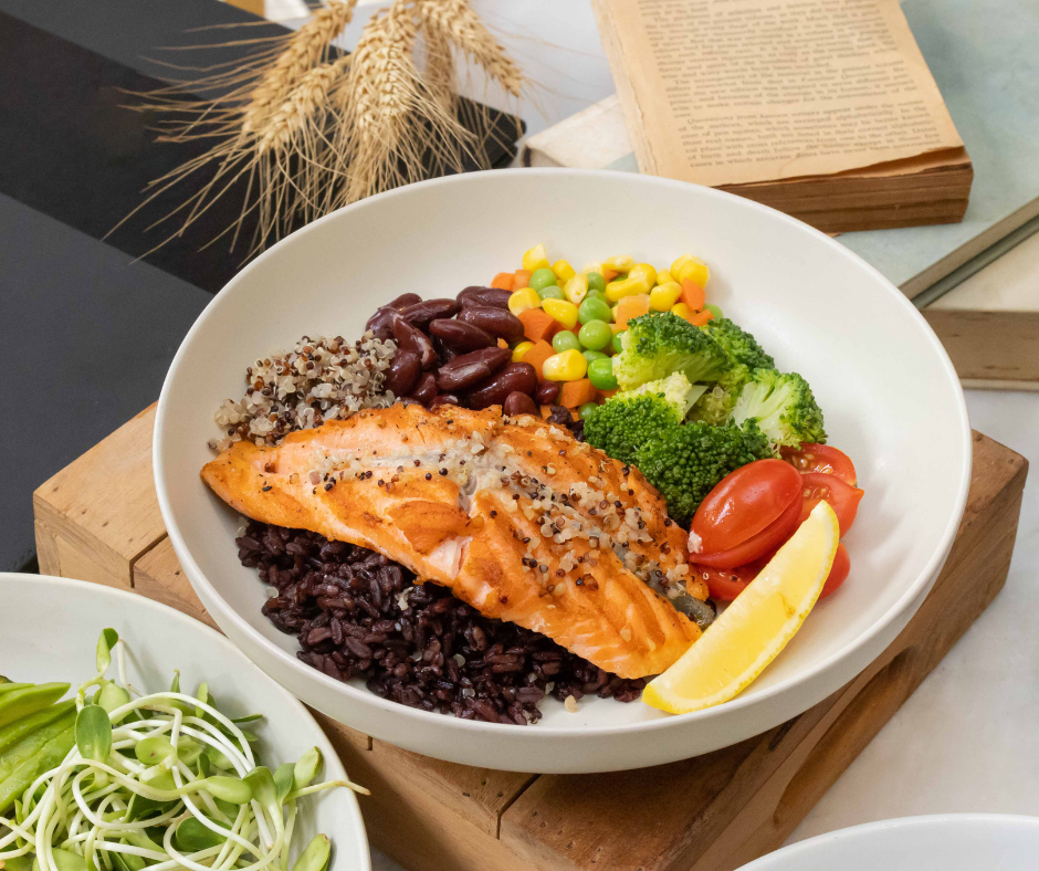 Kuvassa proteiinipitoinen annos, jossa lohta, papuja, parsakaalia, tomaattia, herneitä, maissia ja kvinoaa