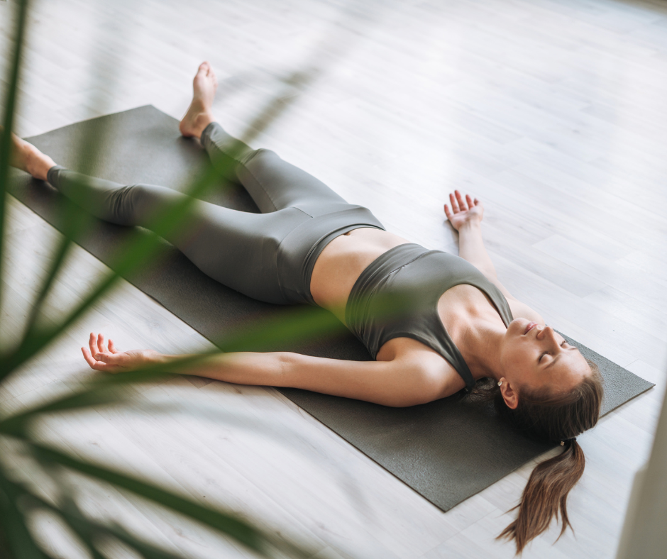 Kuvassa nainen tekee rentoutusharjoitusta lattialla. Kun napa on vedetty sisään syvä hengittäminen kehittää myös syviä vatsalihaksia.
