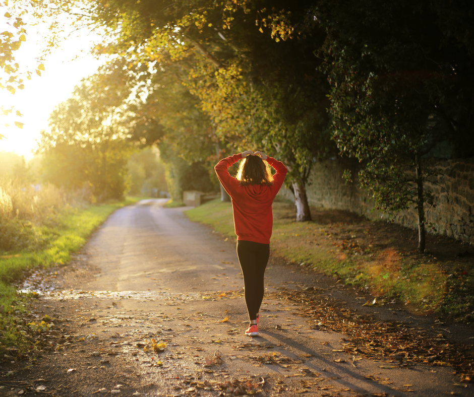 Kuvassa nainen on aamukävelyllä auringonpaisteessa.