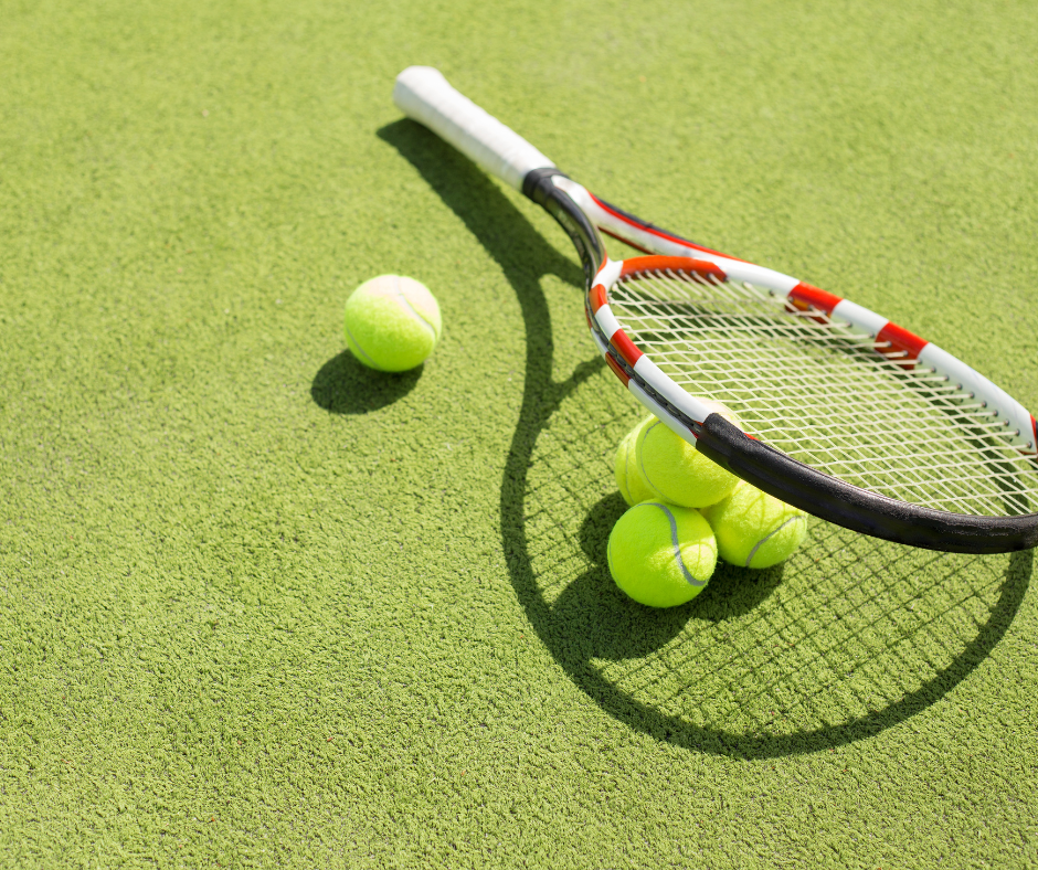 Tennismaila ja neljä tennispalloa tenniskentällä.
