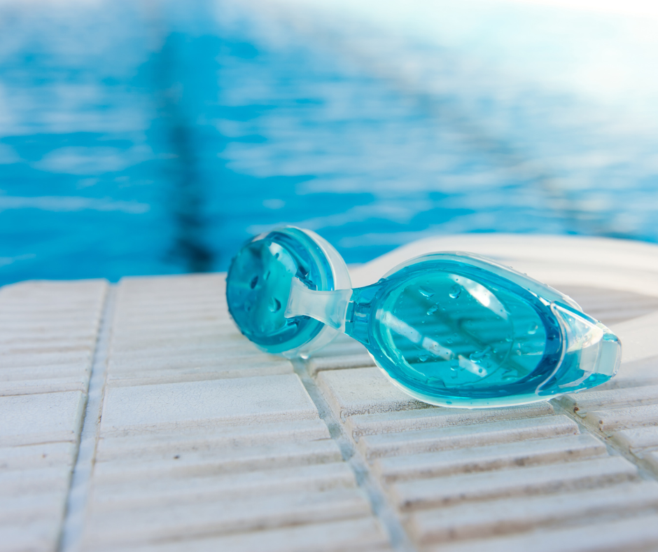 Kuvassa uimalasit uima-altaan laidalla.