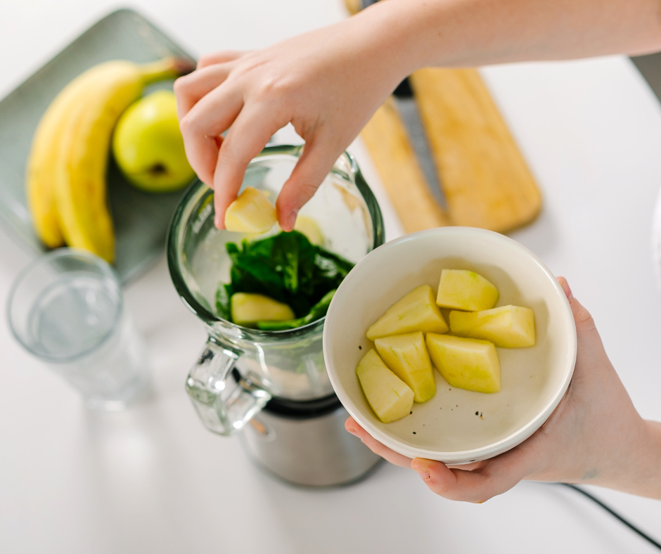 Kuvassa valmistetaan smoothieta, johon tulee mm. pinaattia ja ananasta. Taustalla näkyy omena ja baananeita.