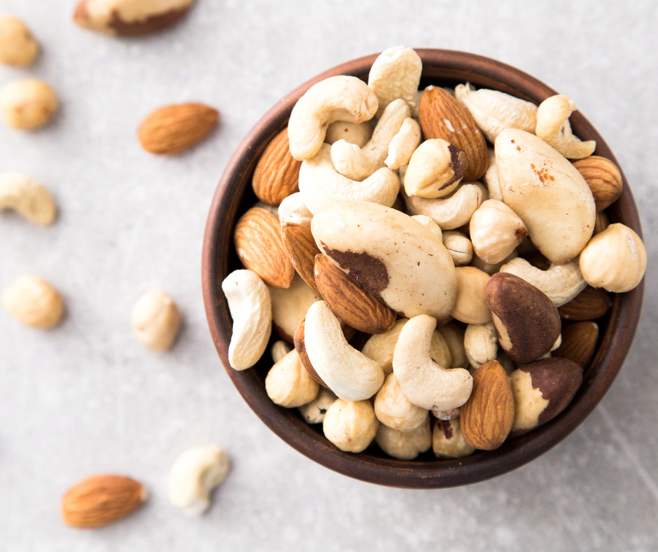 Kuvassa ruskeassa pienessä kulhossa pähkinöitä; cashew, parapähkinä, manteli