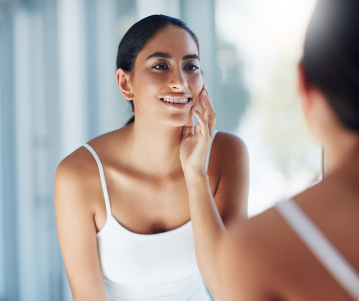 Kuvassa nainen katsoo itseään peilistä.