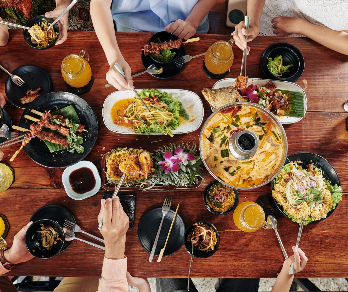 Kuvassa neljä ihmistä ravintolassa, jotka on tilanneet jaettavan menun.