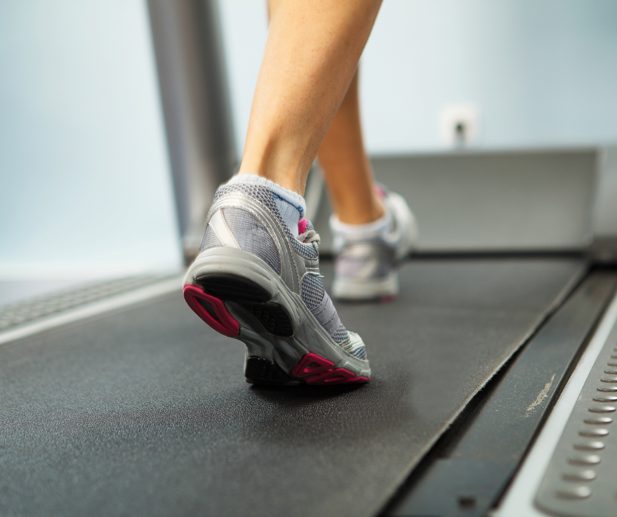 Kuvassa näkyy naisen jalat juoksumatolla