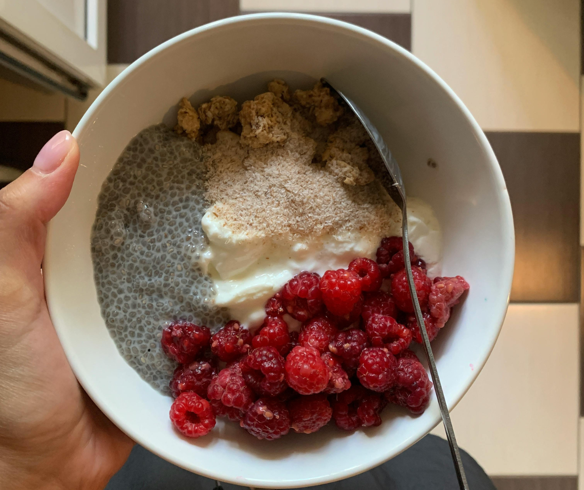 Kuvassa chiavanukasta valkoisella lautasella, lisäksi vadelmia ja granolaa