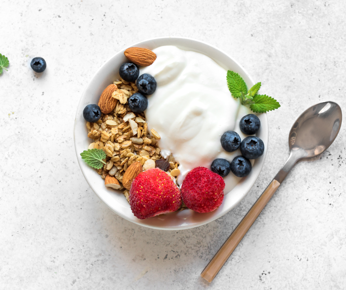 Kuvassa lautasellinen jogurttia, marjoja sekä granolaa