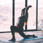 Kuvassa nainen venyttelee talvisella taustalla