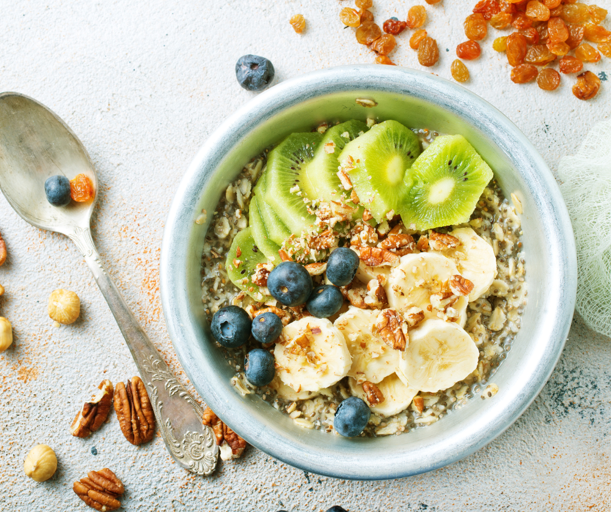 Kuvassa tuorepuuroa, jossa on päällä kiiviä, banaania ja mustikoita