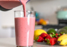 Kuvassa henkilö kaataa smoothieta lasiin
