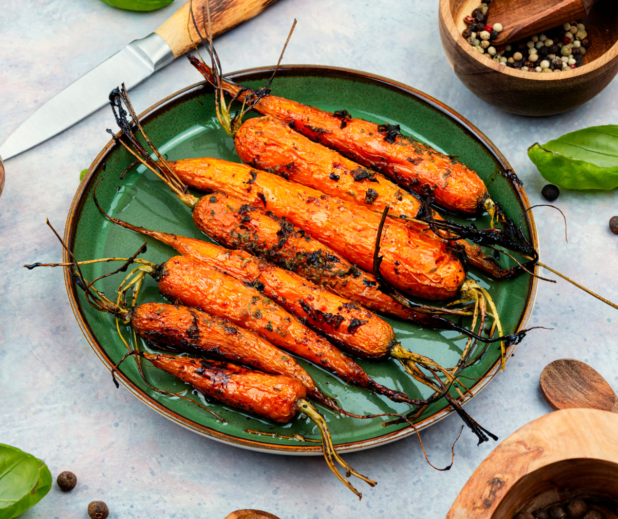 Kuvassa paahdettuja porkkanoita vihreällä lautasella