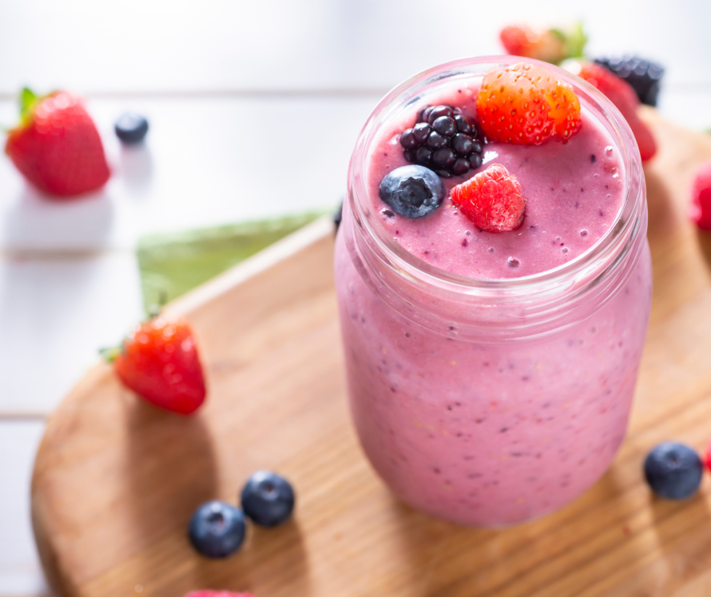 Kuvassa marjainen smoothie, jossa koristeena mansikkaa, karhunvadelmaa ja mustikkaa