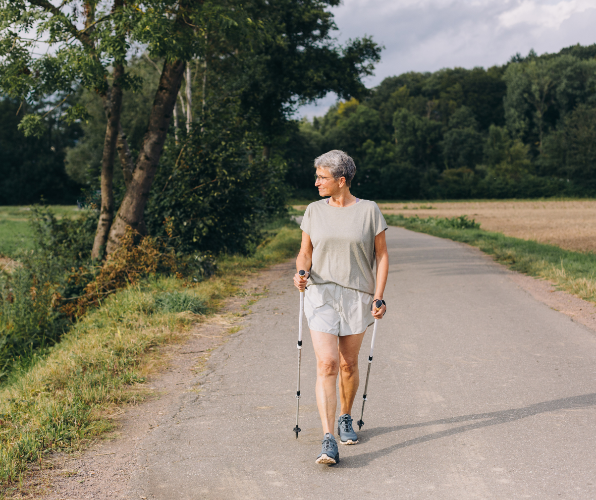 Kuvassa nainen on sauvakävelyllä