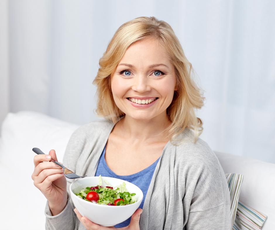 Nainen syö tuoretta vihersalaattia kotona.