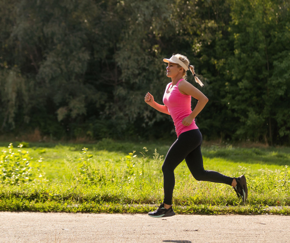 Nainen juoksee kesällä lippis päässä.