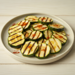Kesäkurpitsaviipaleita grillattuna lautasella.