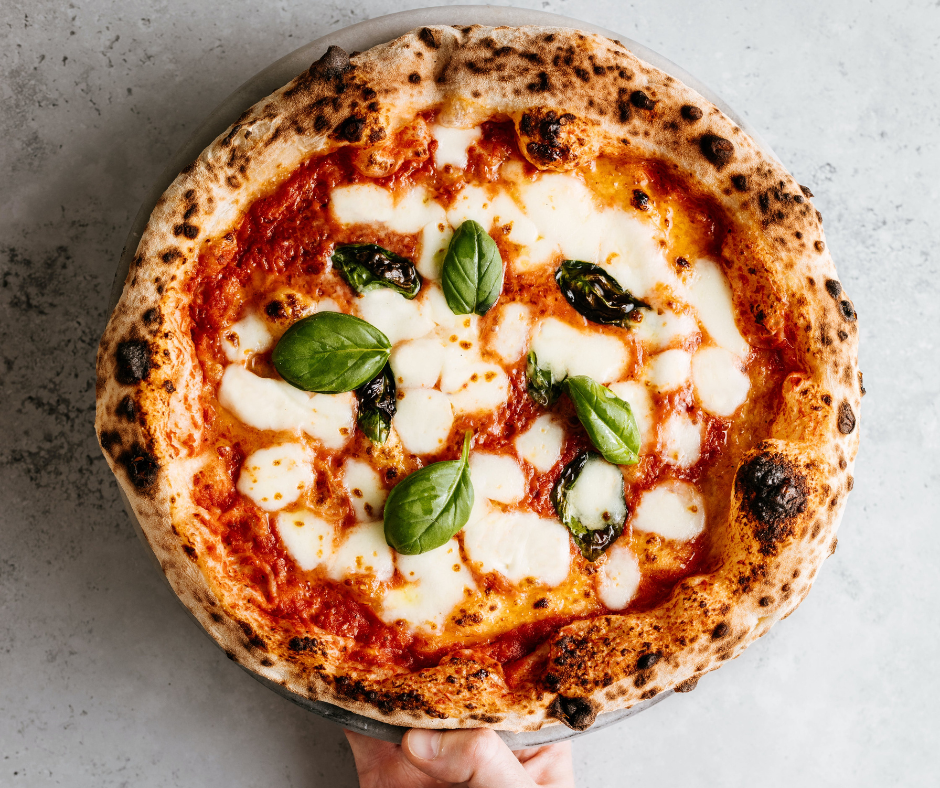 Napolilainen pizza, jonka päällä juustoa ja basilikaa.