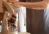 Mies valmistaa smoothieta ja kaataa blenderiin aineksia.