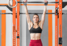 Nainen roikkuu crossfit salilla tangossa.