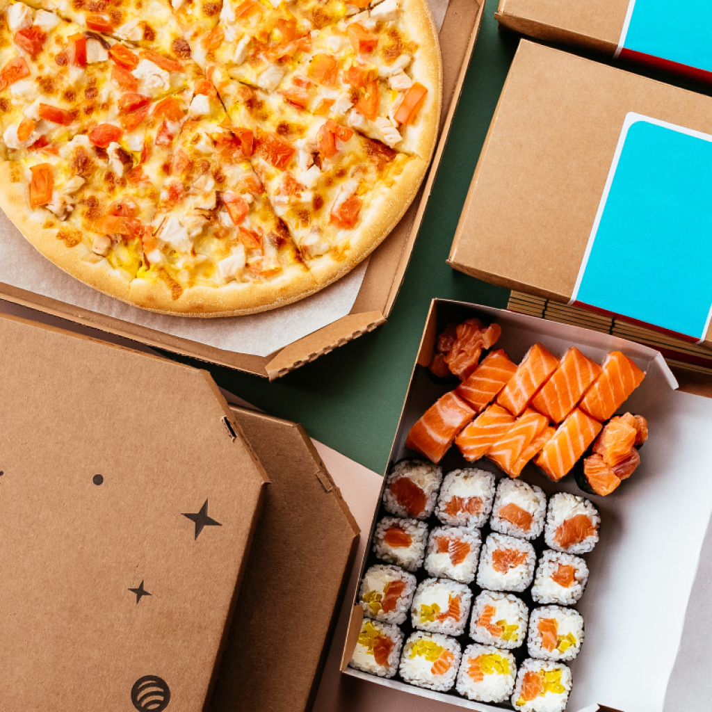 Pizza laatikossa ja sushia laatikossa.