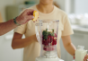 Pariskunta valmistaa smoothieta keittiössä.