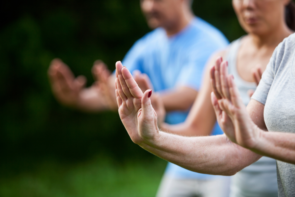 Tai chi -liikkeitä tekeviä puistossa.