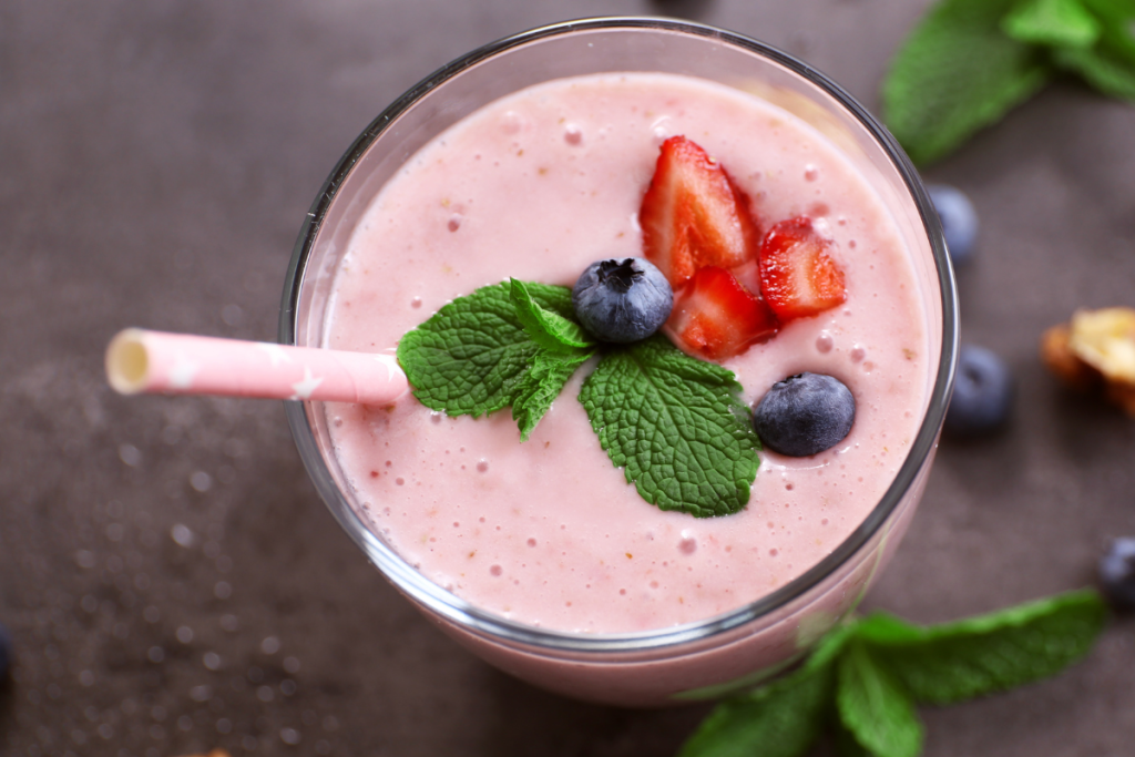 Smoothie ylhäältä päin kuvattuna. Päällä mansikoita ja mustikoita.