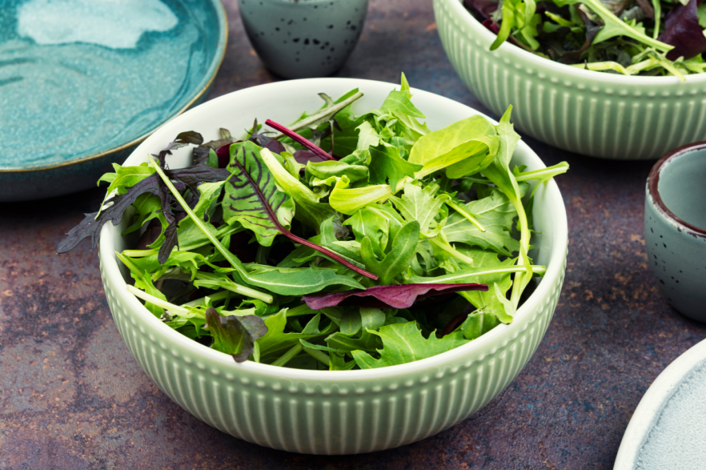 Kulho, jossa erilaisia lehtivihreitä, kuten rucolaa.