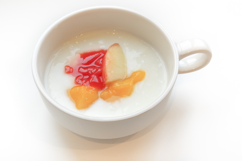 Annos cream o f rice -puuroa. Päällä persikan viipaleita.