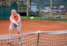 Vanhempi nainen pelaa tennistä.
