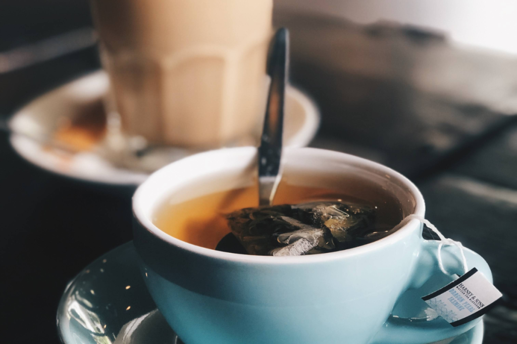 Kahvilan pöydällä teetä ja taustalla cafe latte.