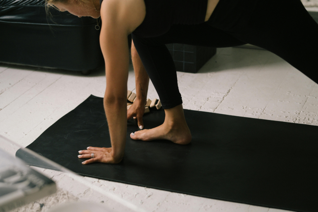 Nainen tekemässä pilates-liikettä matolla.